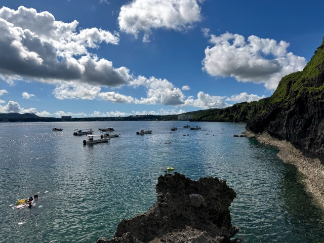 Dive boats moored in front of the cliffs at Cape Maeda